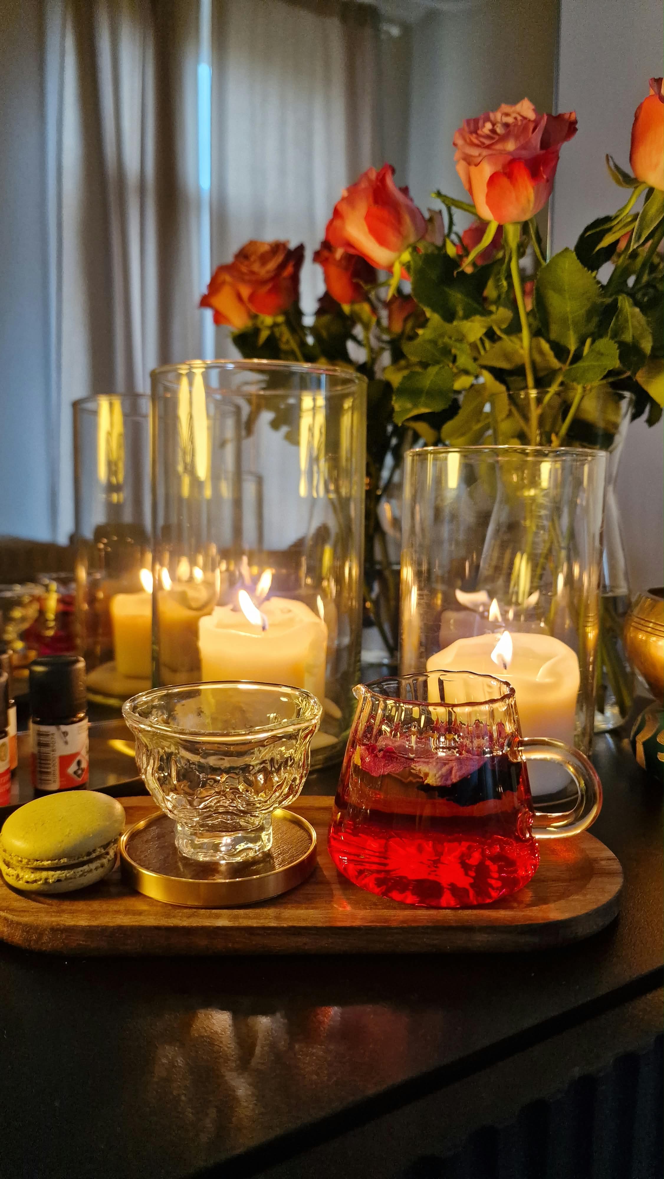 Kräutertee, Kerzen und Rosen auf einem Tablett
